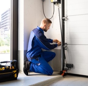 Técnico de DUVINOX realizando la instalación y ajuste de una puerta automática seccional con enfoque profesional